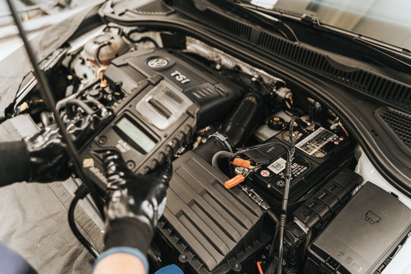 An engine bay with the battery visible under the hood