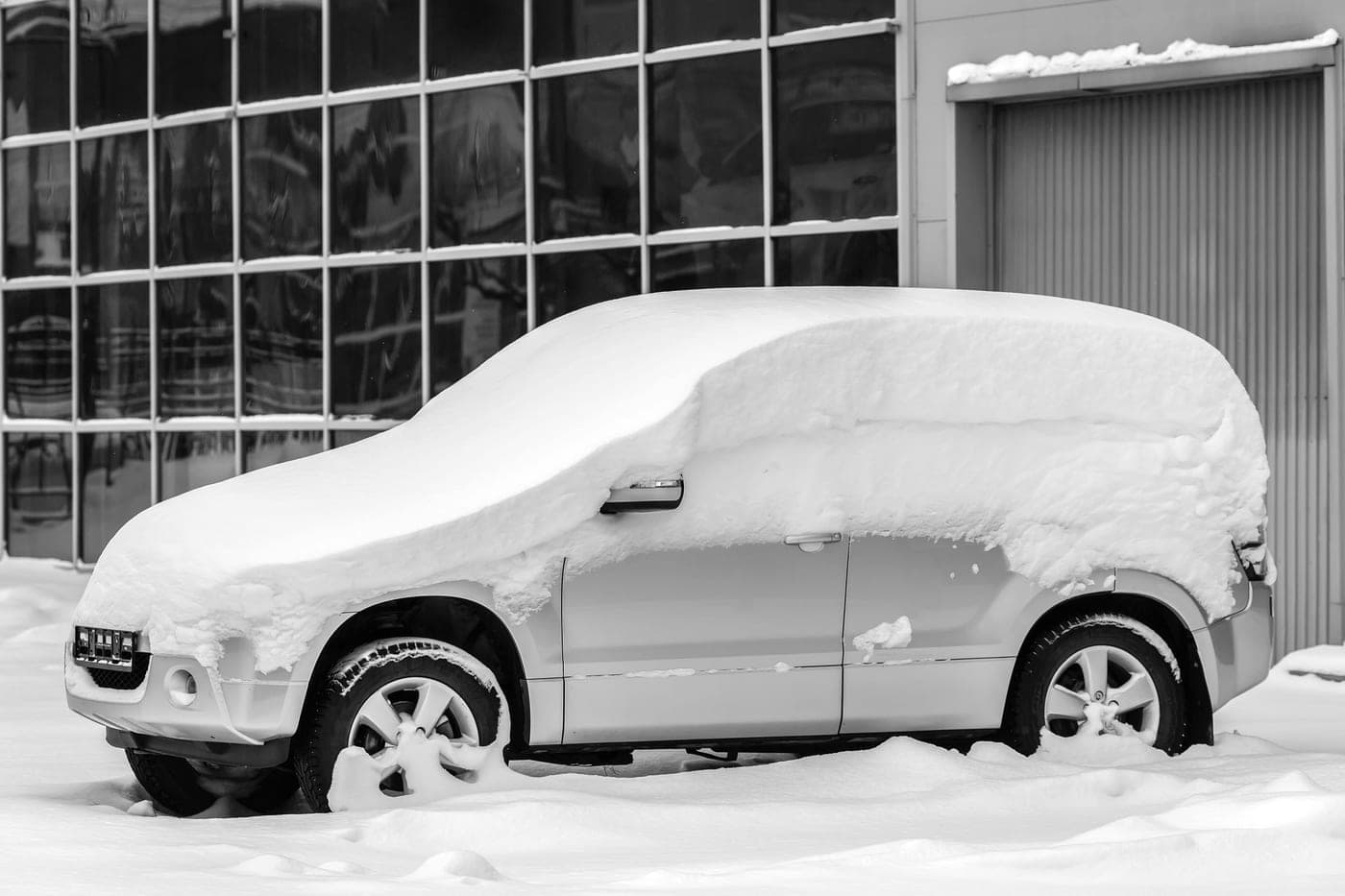A parked car under a covering of snow