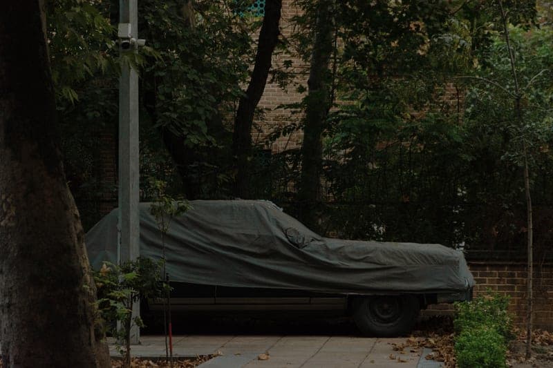 A car under a fitted outdoor cover in winter - a stand-in for the Budge Rain Barrier Car Cover, not a photograph of this model