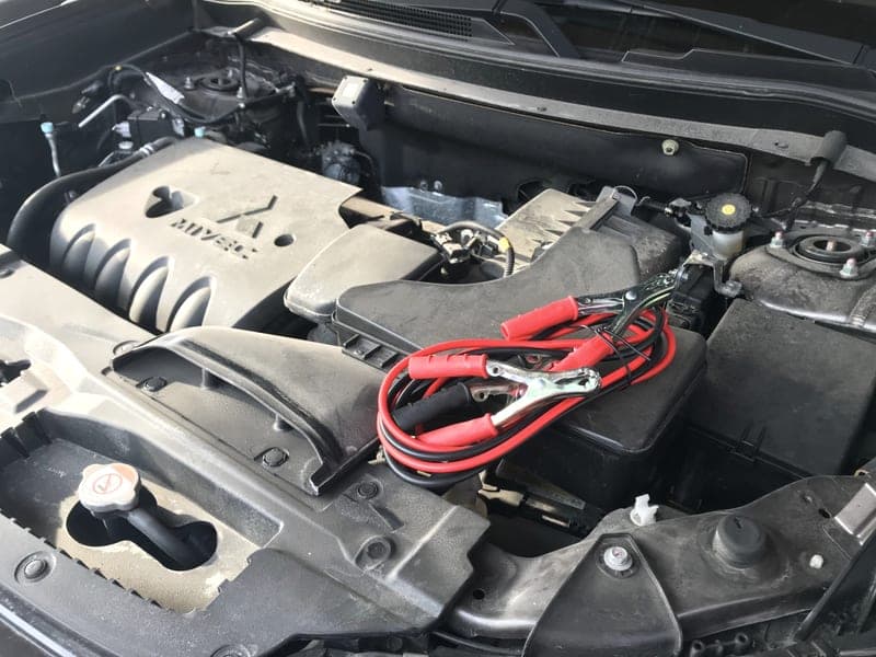 Jump leads clamped to a car battery terminal - a stand-in for the NOCO Boost Plus GB40 Jump Starter, not a photograph of this model