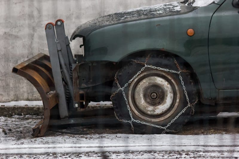 A tire chain fitted over a wheel in snow - a stand-in for the Security Chain Company Super Z6 Cable Chains, not a photograph of this model